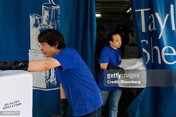 Employees carry boxes of seafood at a Taylor Shellfish Co. Warehouse in the Tai Wai area of Hong Kong, China, on Friday, June 17, 2016. Geoducks are...