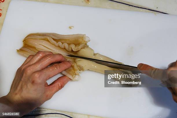 Chef cuts a geoduck at the Taylor Shellfish Farms restaurant in the Sai Ying Pun area of Hong Kong, China, on Friday, June 17, 2016. Geoducks are the...