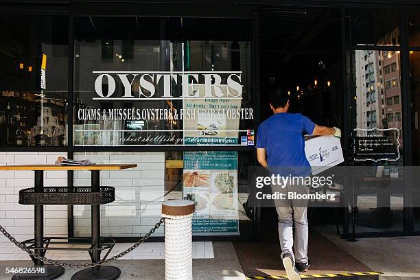 An employee carries a box of geoducks into the Taylor Shellfish Farms restaurant in the Sai Ying Pun area of Hong Kong, China, on Friday, June 17,...