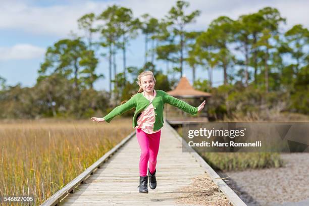 caucasian girl running on wooden walkway - skipping along stock pictures, royalty-free photos & images