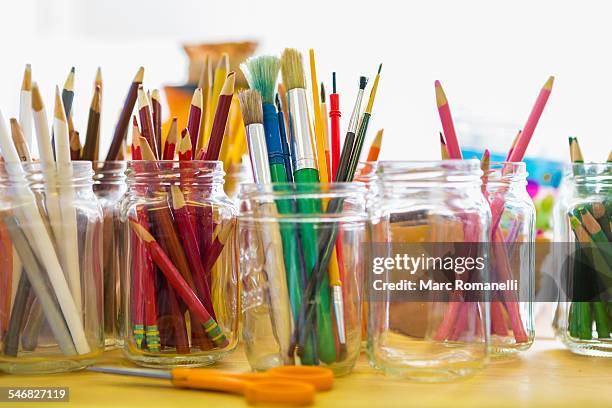 close up of jars of colored pencils and paintbrushes - konstmateriel bildbanksfoton och bilder