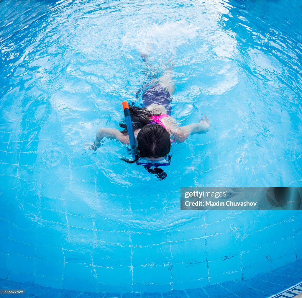 Caucasian girl snorkeling in swimming pool