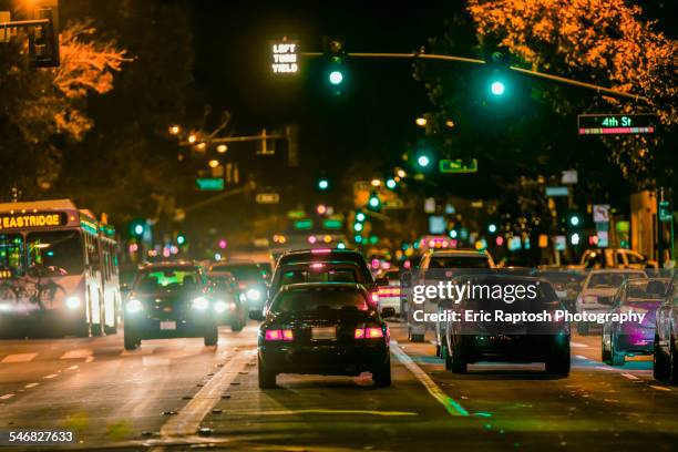 cars driving in city traffic at night - stoplight stock pictures, royalty-free photos & images