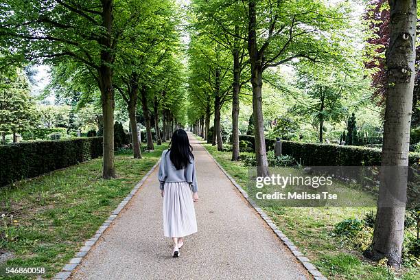 woman walking in park - copenhagen park stock pictures, royalty-free photos & images