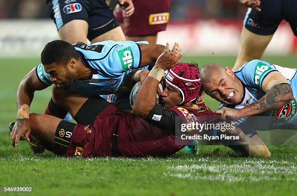 Johnathan Thurston of the Maroons is tackled by David Klemmer of the Blues during game three of the State Of Origin series between the New South...