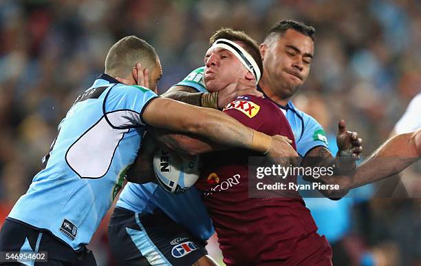 Josh McGuire of the Maroons is tackled by Andrew Fifita of the Blues during game three of the State Of Origin series between the New South Wales...