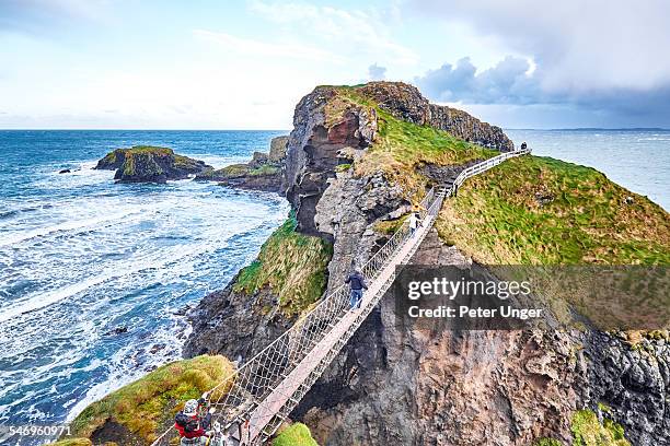 carrick-a-rede rope bridge, northern ireland - northern ireland rope bridge stock-fotos und bilder