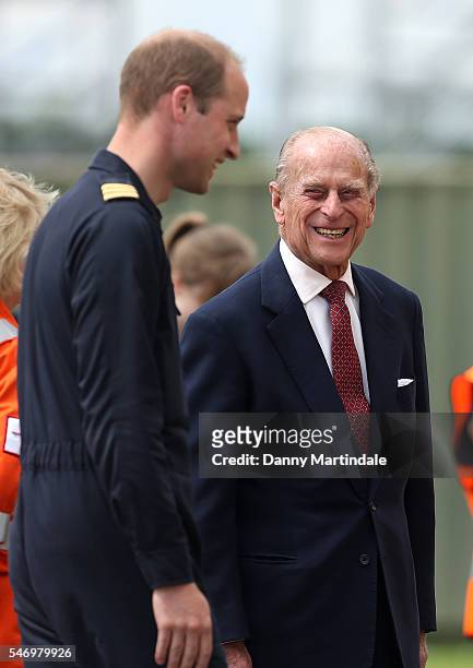 Prince William, Duke of Cambridge jokes with Prince Philip, Duke of Edinburgh as he says goodbye after visiting the new East Anglian Air Ambulance...