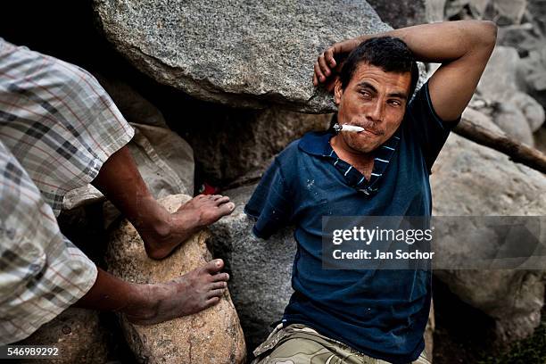 Young Honduran immigrant, having his arm amputated by a train during his previous attempt to get illegally to the United States, smokes marijuana on...