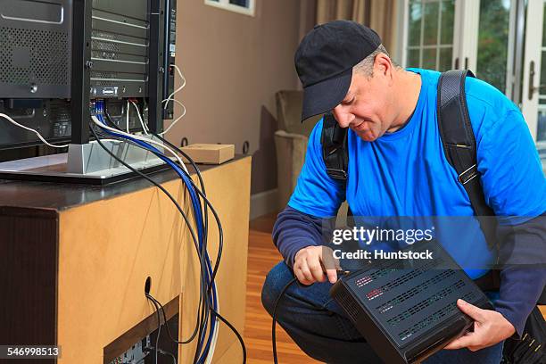 service man connecting cable to modem box for home tv - cable installer stockfoto's en -beelden