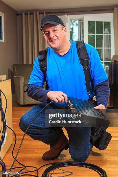 service man connecting cable to modem box for home tv - cable installer stockfoto's en -beelden