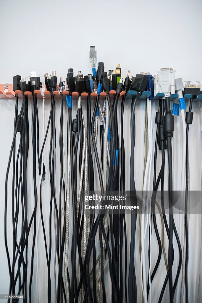 Cables arranged in rows on a wall rack.