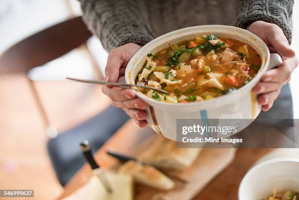 close up view of a man holding a bowl with a vegetable stew. - eintopf von oben stock-fotos und bilder