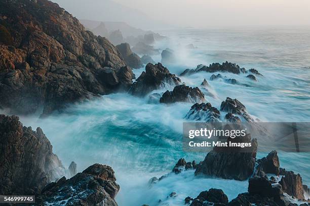 the pacific ocean coastline, with waves crashing against the shore. - waves crashing on rocks stock pictures, royalty-free photos & images