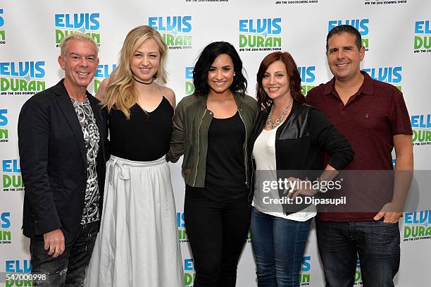 Demi Lovato poses with Elvis Duran, Bethany Watson, Danielle Monaro, and Skeery Jones of "The Elvis Duran Z100 Morning Show" at Z100 Studio on July...