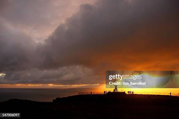 norway, nordkapp, midnight sun and silhouette people in background - midnight sun norway stock-fotos und bilder