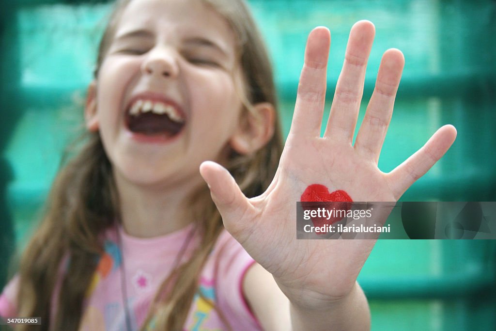 Girl with a heart drawn on the palm of her hand