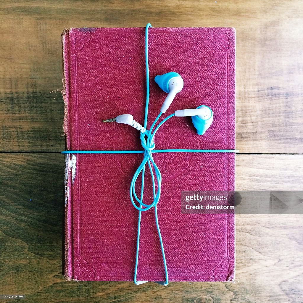Headphones wrapped around an old book
