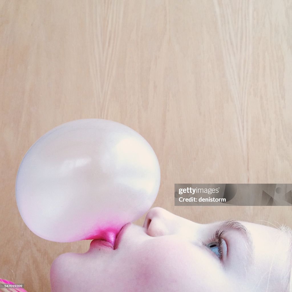 Portrait of a girl blowing a bubblegum bubble