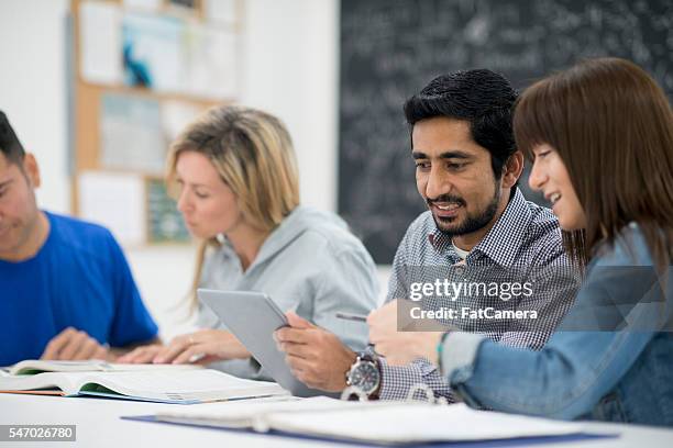 doing research together on a tablet - oudere student stockfoto's en -beelden