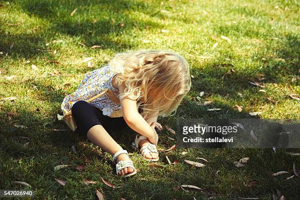 petite fille attachant des chaussures - sandales photos et images de collection