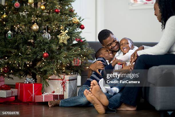 father playing with his kids on christmas day - african ethnicity christmas stock pictures, royalty-free photos & images