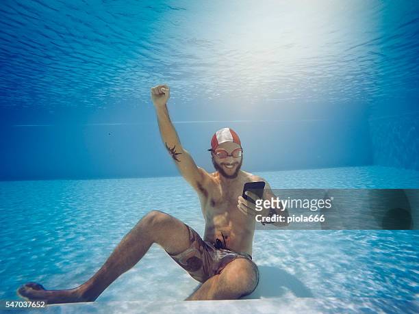 mann süchtig nach online-glücksspiel-wetten unter wasser - aquatic sport stock-fotos und bilder