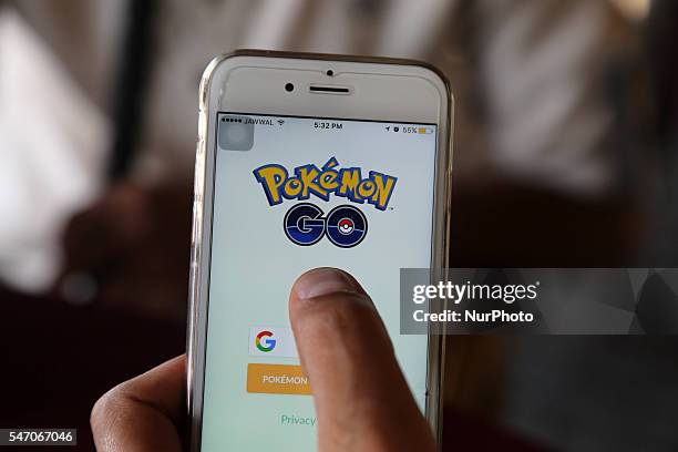 Palestinian man holds up her cell phone as she plays the Pokemon Go game in gaza city, July 13, 2016.