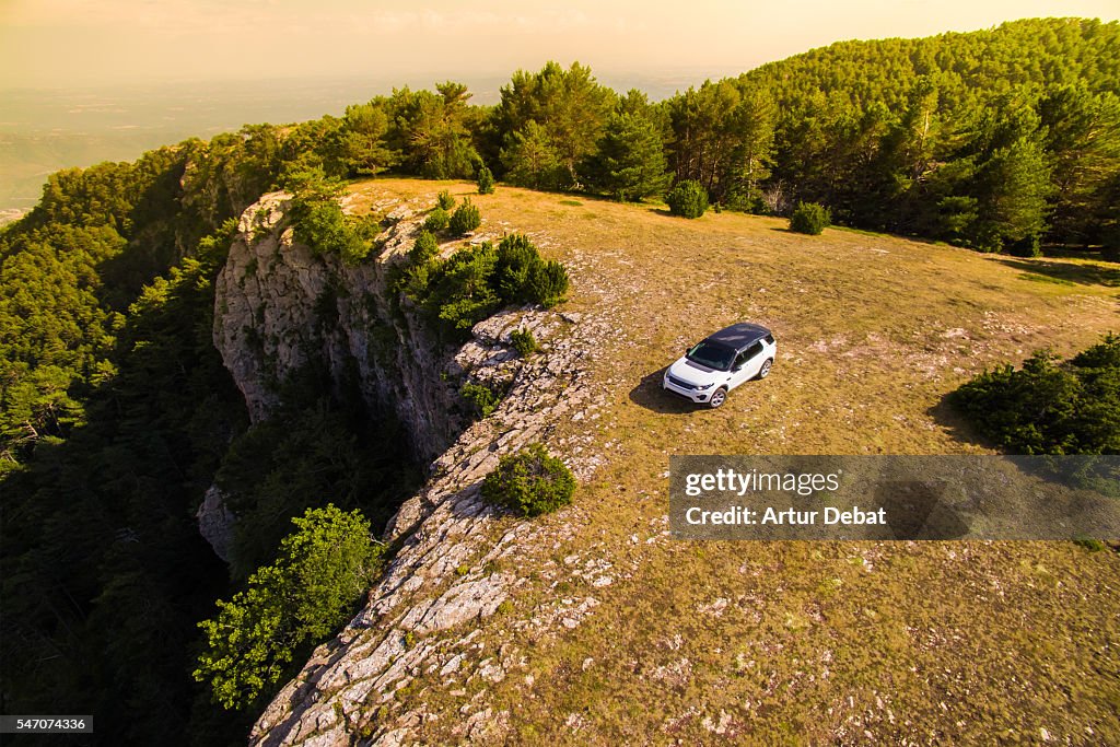 Suv car place on the top of mountain with beautiful view of the Catalan Pyrenees on sunset light during a road trip to discover the hidden places of the region.