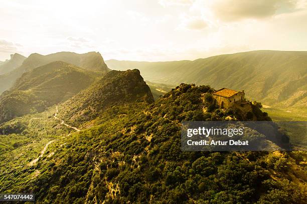 aerial view of a beautiful church on top of mountain with stunning summits on sunset light in the catalan pyrenees. - catalan stock pictures, royalty-free photos & images