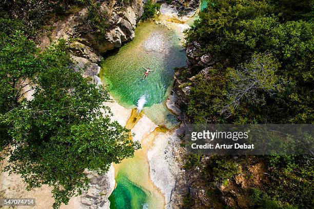 aerial picture of a kid swimming in a paradise green pools created in a creek in the catalan pyrenees during summer. - catalonia stockfoto's en -beelden