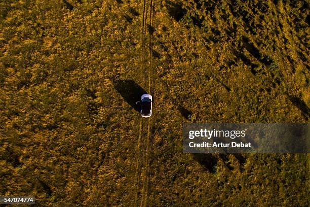 aerial picture of a 4x4 car driving over the beautiful hills on sunset in the catalan pyrenees during a summer road trip. - car aerial view stock pictures, royalty-free photos & images