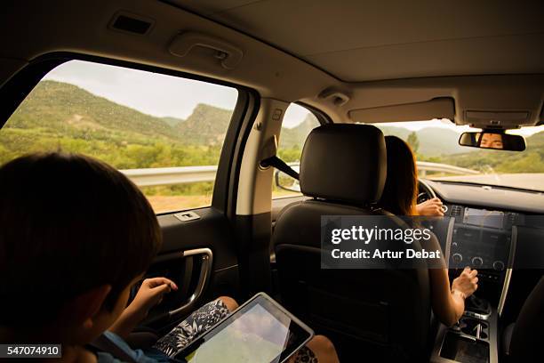 family mother driving a suv car during a road trip travel through the catalan pyrenees roads. - family inside car fotografías e imágenes de stock