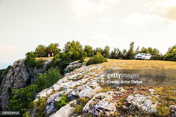 family adventure travel around the pyrenees mountains driving with suv car to the top of the mountains with nice views on sunset. - suv berg stock-fotos und bilder