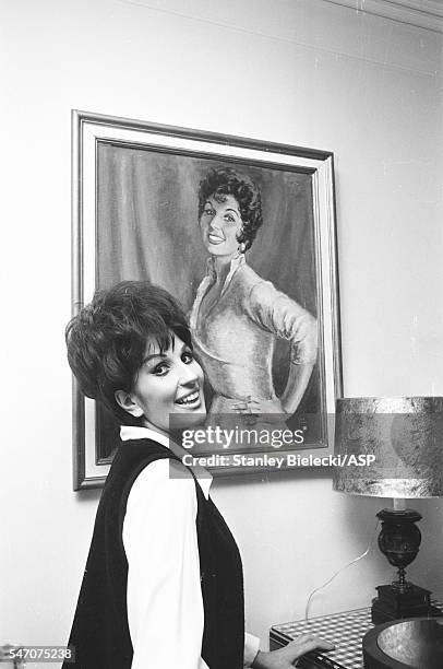 Portrait of Alma Cogan at home posing with a portrait of herself, London, circa 1964.