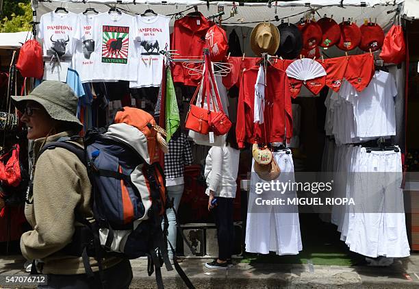 Pilgrim trekking the Way of St. James walks through a street market during the San Fermin Festival in Pamplona, northern Spain, on July 13, 2016. The...