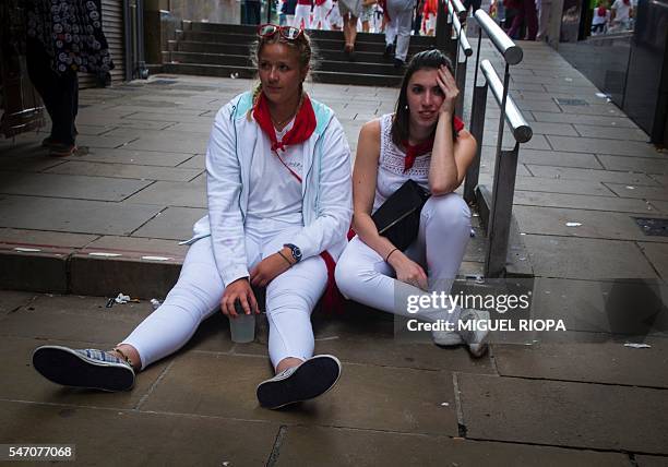 Two women sit in a street during the San Fermin Festival in Pamplona, northern Spain, on July 13, 2016. The festival is a symbol of Spanish culture...