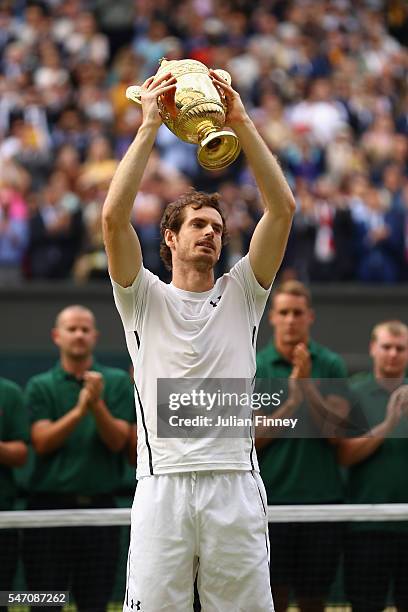 Andy Murray of Great Britain lifts the trophy following victory in the Men's Singles Final against Milos Raonic of Canada on day thirteen of the...