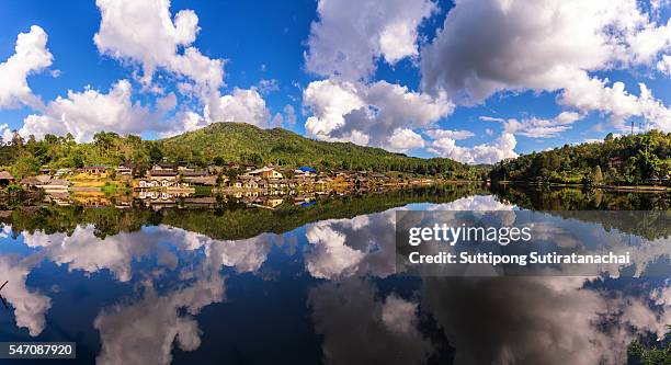 beautiful lake and sky view of village and mountain reflection - ban rak thai stock pictures, royalty-free photos & images