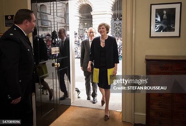 New British Prime Minister Theresa May and her husband Philip John walk into 10 Downing Street in London, on July 13, 2016 after meeting Queen...