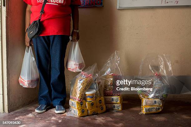 CLAPs member carries plastic bags filled with groceries for delivery in the Catia neighborhood on the outskirts of Caracas, Venezuela, on Saturday,...