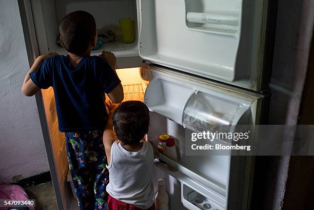 Young childern look in an empty refrigerator at a home in the Catia neighborhood on the outskirts of Caracas, Venezuela, on Thursday, June 30, 2016....