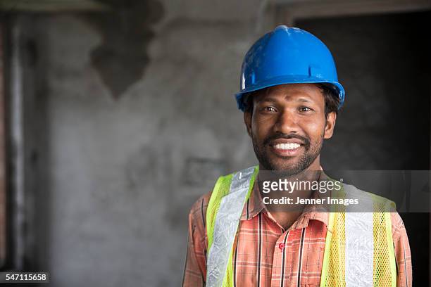 portrait of an indian man at a construction site - indian subcontinent ethnicity stock pictures, royalty-free photos & images