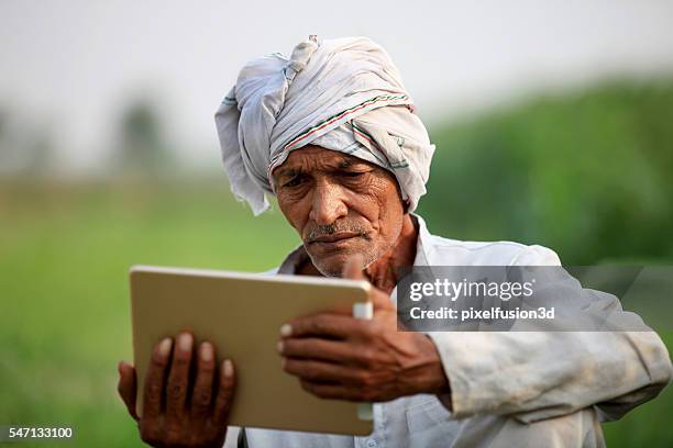 old farmer holding digital tablet - indian village people stock pictures, royalty-free photos & images