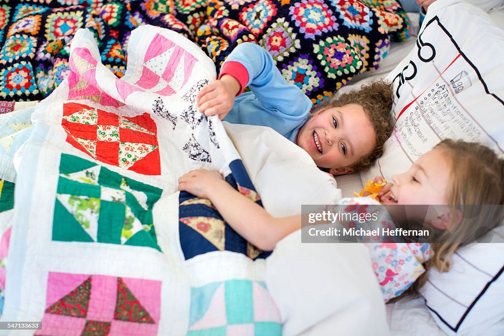 Two young girls playing in bed