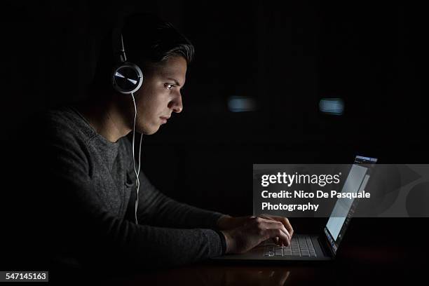 young man using laptop - addiction mobile and laptop stock-fotos und bilder