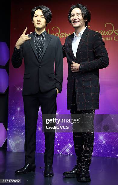 Singer and actor Chen Chang poses with his wax figure at Madame Tussauds Shanghai on July 13, 2016 in Shanghai, China.