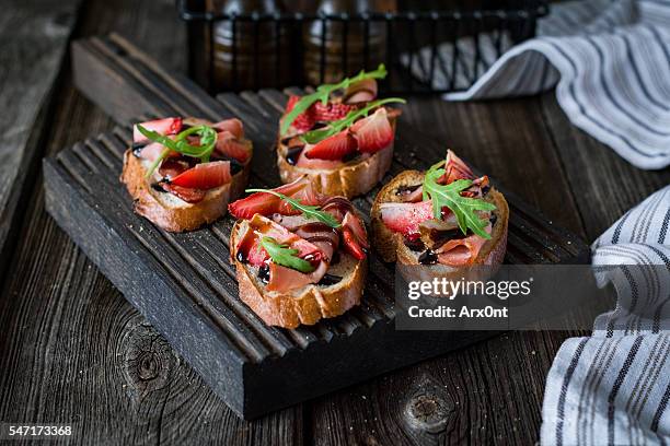 fruit and meat bruschettas, set for wine - canapé fotografías e imágenes de stock