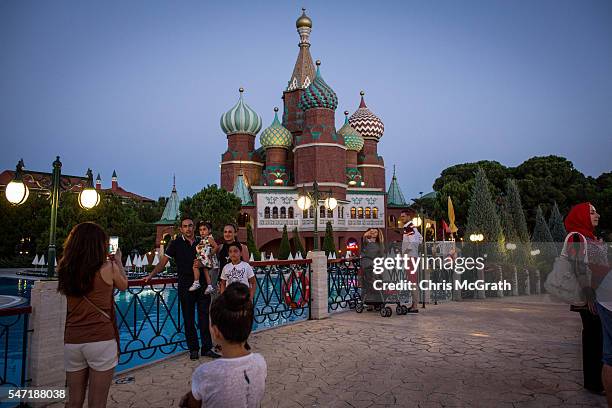 Tourists take photographs in front of a replica of Russia's St Basil's Cathedral at a Russian themed resort on July 11, 2016 in Antalya, Turkey....