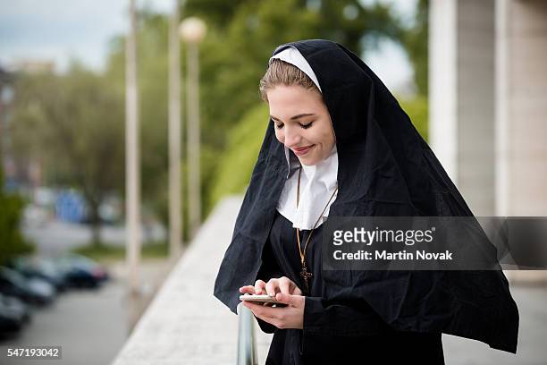 modern life - nun with mobile - nun stock pictures, royalty-free photos & images